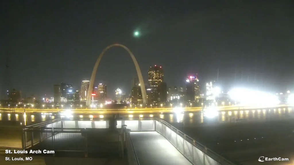 A meteor blazing green over Missouri's Gateway Arch at night.